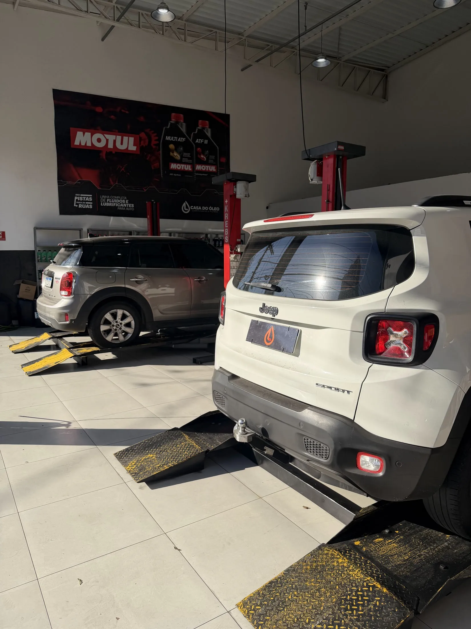 Jeep Renegade branco em atendimento no box da oficina